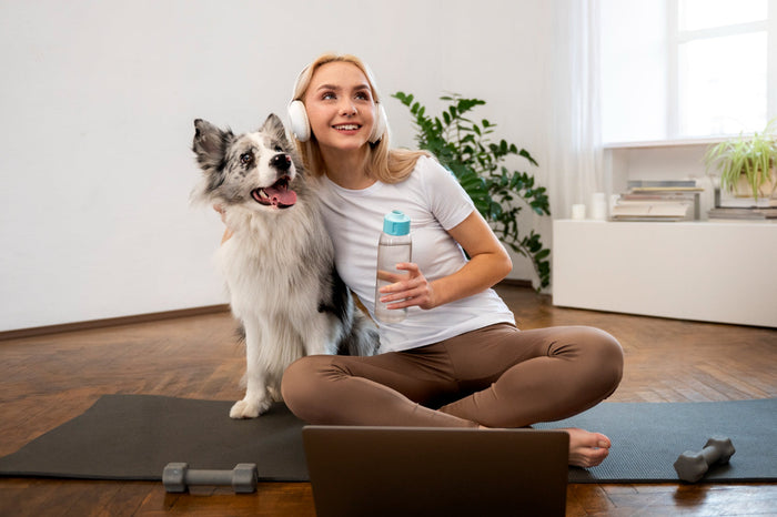 Person doing yoga accompanied by her dog